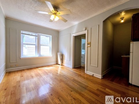 A room with wooden floors and a ceiling fan.