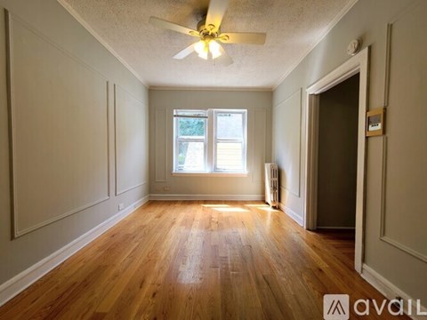 A room with wooden floors and a ceiling fan.