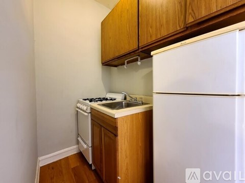 A kitchen with a white fridge, white stove and white sink.