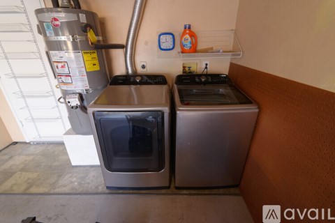 A kitchen with two ovens and a wall-mounted gas tank.
