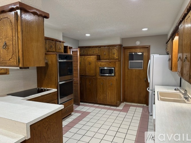 A kitchen with wooden cabinets and a white counter top.