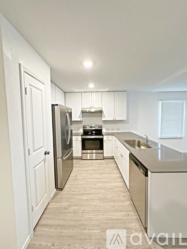 A kitchen with white cabinets and stainless steel appliances.