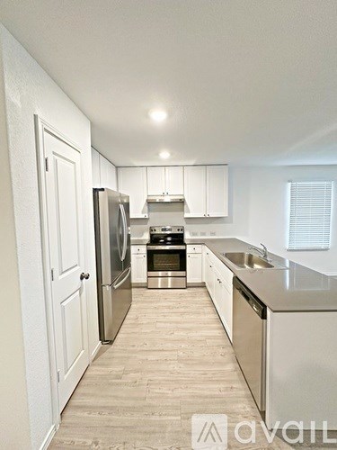 A kitchen with white cabinets and stainless steel appliances.