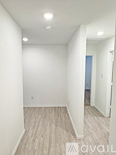 A room with wooden flooring and white walls.