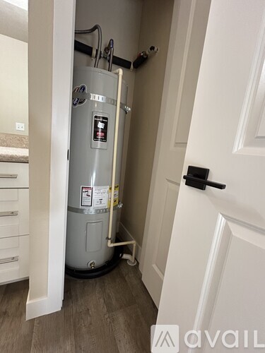 A water heater is installed in a narrow hallway.