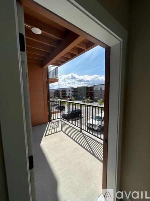 A balcony with a metal railing and a view of the sky and buildings.