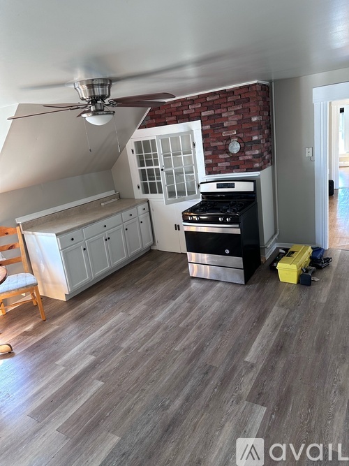 A kitchen with a brick wall and a ceiling fan.