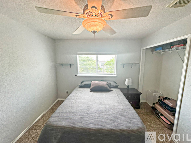 A bedroom with a bed, dresser, and window.