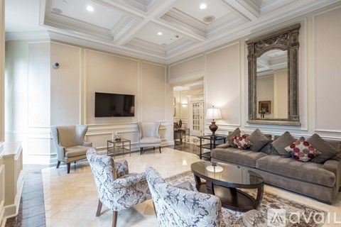 A living room with a grey couch and a large mirror on the wall.