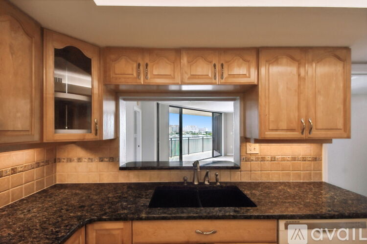 A kitchen with wooden cabinets and a black granite countertop.