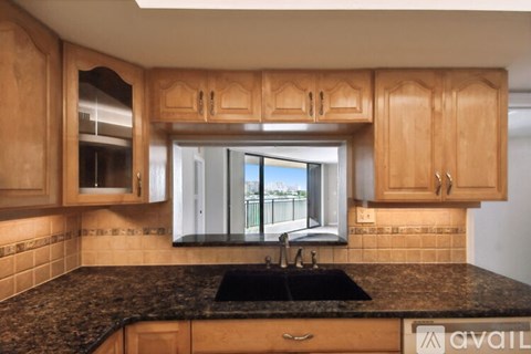 A kitchen with wooden cabinets and a black granite countertop.