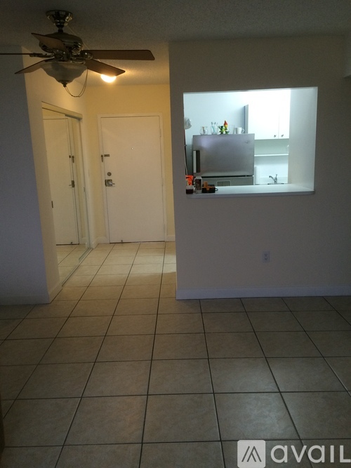 A room with a ceiling fan and a tiled floor.