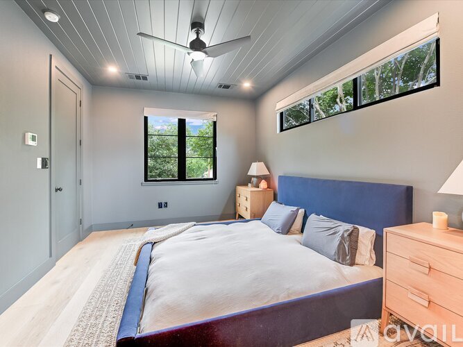 A bedroom with a bed, dresser, and window.