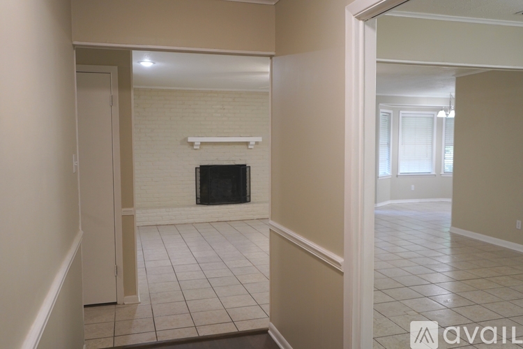 A living room with a fireplace and a doorway leading to another room.