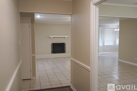 A living room with a fireplace and a doorway leading to another room.