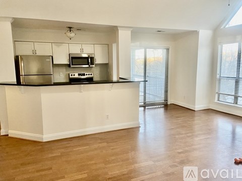 A kitchen with white cabinets and a wooden floor.