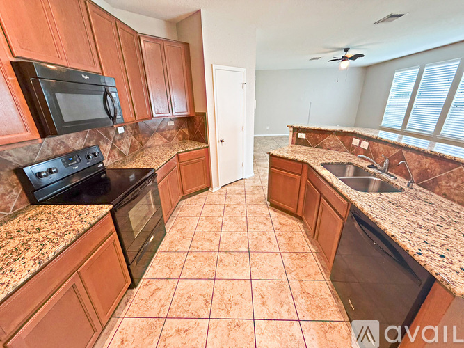 A kitchen with brown cabinets and granite countertops.