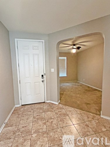 A room with a white door and a fan on the ceiling.