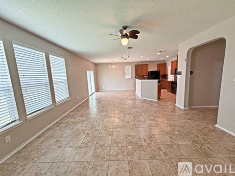 A spacious room with a ceiling fan and tiled flooring.