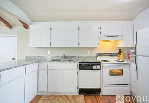 A kitchen with white cabinets and a granite countertop.