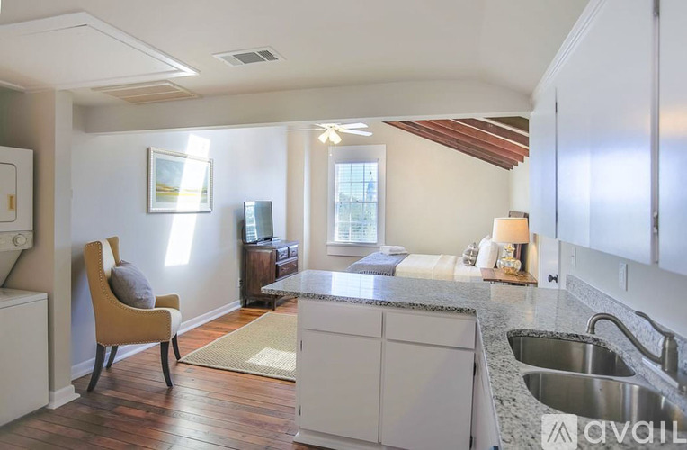 A kitchen with a sink, a chair and a window.