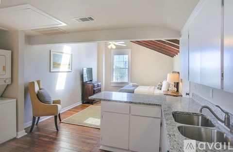 A kitchen with a sink, a chair and a window.