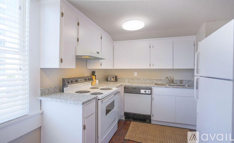 A kitchen with white cabinets and appliances.