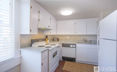 A kitchen with white cabinets and appliances.