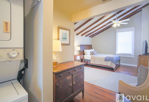 A bedroom with a bed, dresser, and ceiling fan.