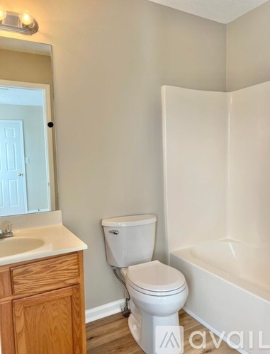 A white toilet sits next to a bathtub in a bathroom.