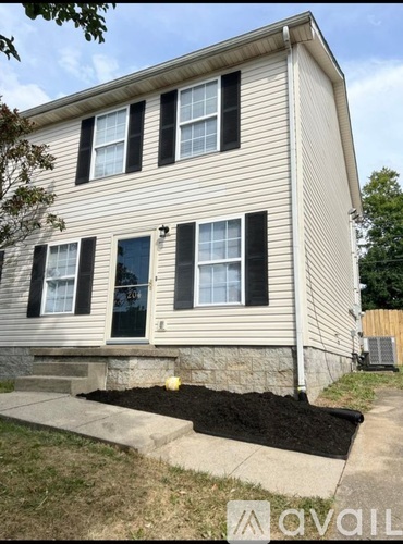 A house with a grey siding and black shutters.