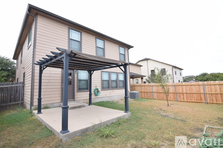 A house with a covered entrance and a fence in the background.