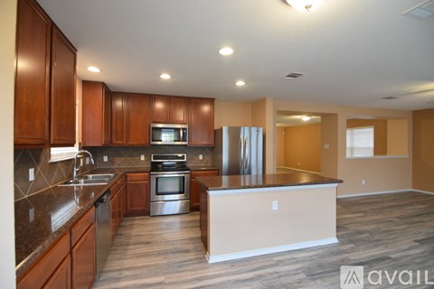 A kitchen with wooden cabinets and a stainless steel oven.