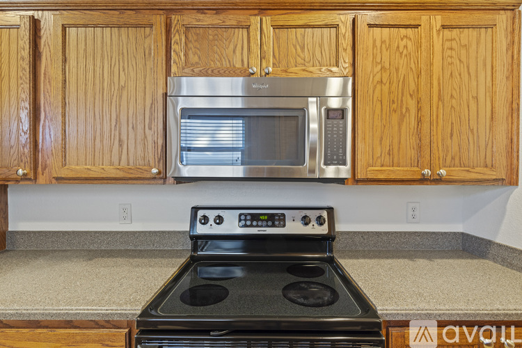 A kitchen with wooden cabinets and a black stove top oven.
