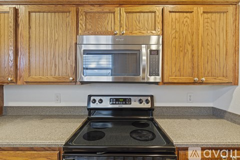 A kitchen with wooden cabinets and a black stove top oven.