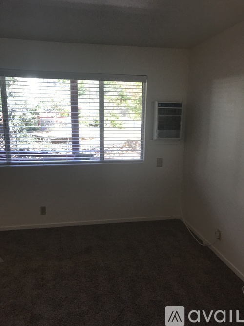 A room with a window and a car parked outside.
