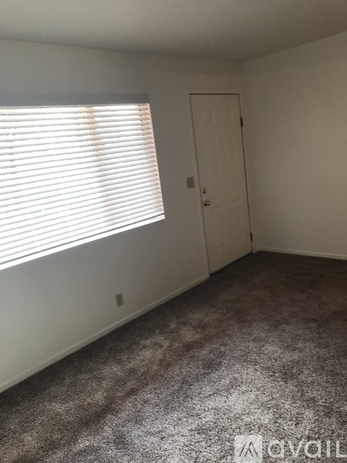 A room with a carpeted floor and a door.
