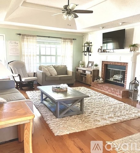 A living room with a fireplace and a television on the wall.