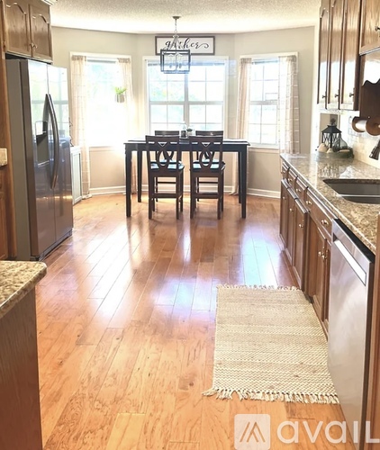 A kitchen with wooden floors and a table set for two.