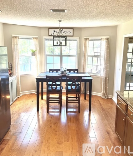 A dining room with a table and chairs.