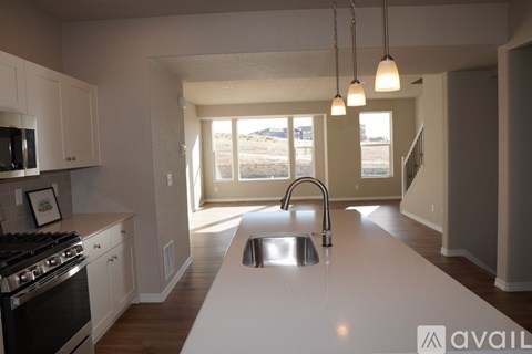 A kitchen with a stove, sink, and cabinets.