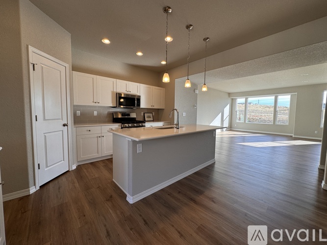 A spacious kitchen with wooden floors and a large island.