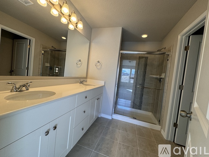 A bathroom with a sink, mirror, and shower.