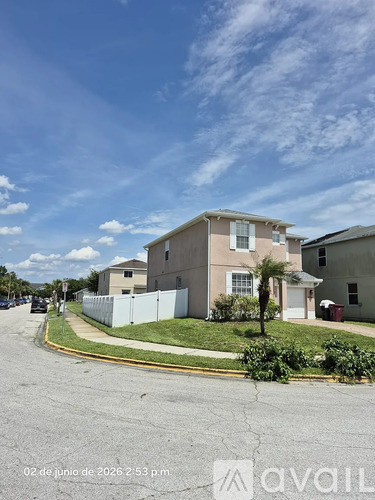 A house with a white fence is shown in the image.