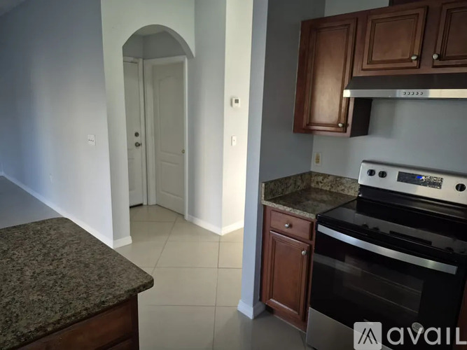 A kitchen with a granite countertop and a stove top oven.