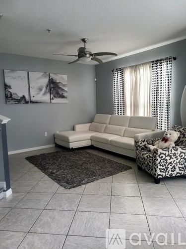A living room with a white couch and a rug.