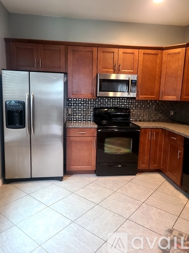A kitchen with a black oven and a silver refrigerator.