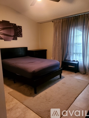 A bedroom with a large bed and a ceiling fan.