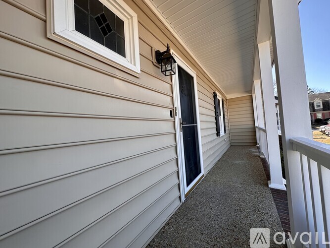 A balcony with a grey carpet and white railings.