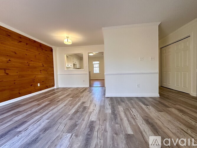 A spacious room with wooden flooring and a white door.